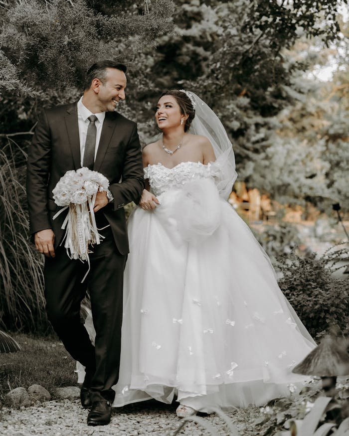 Happy bride and groom walking together outdoors on their wedding day.